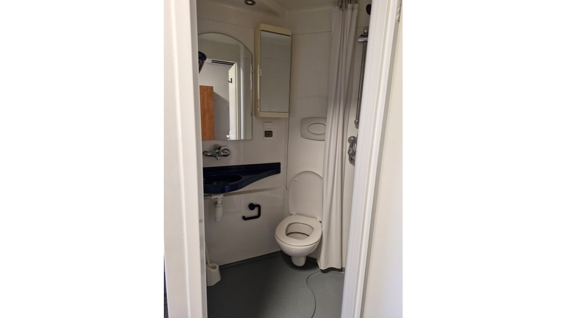 Salle de bain avec toilettes, lavabo douche et rangement 